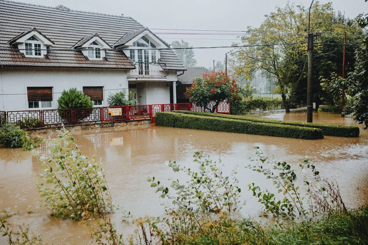 Suburban home surrounded by floodwaters showing how yard drainage affects the foundation